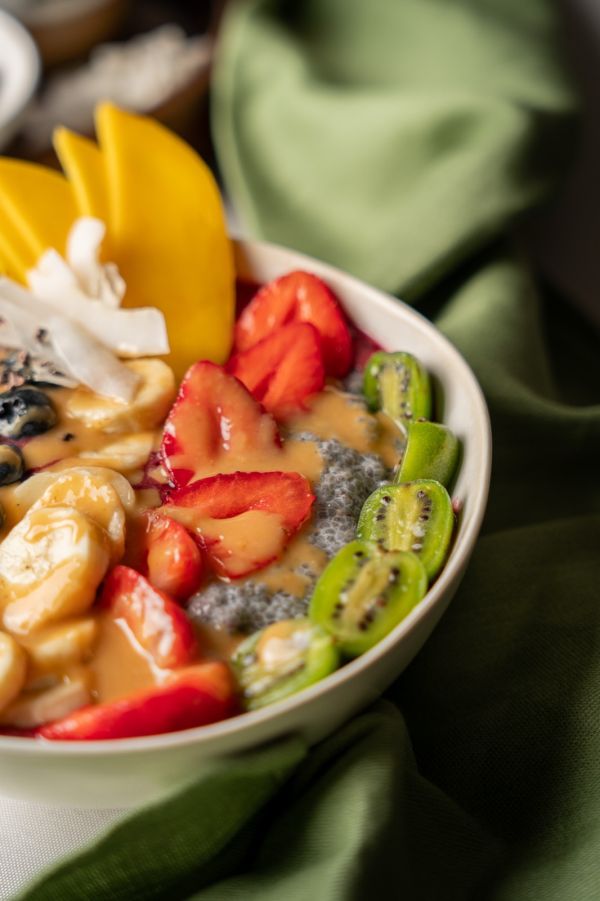 Nahaufnahme der Bowl mit Erdbeeren, Mango, Mini-Kiwi, Banane und Chiasamen