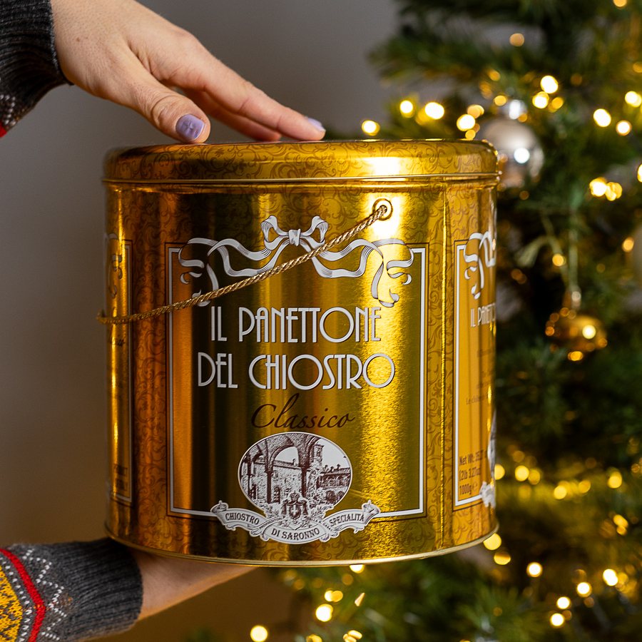 Panettone von Chiostro di Saronno in der goldenen Metalldose vor dem Weihnachtsbaum